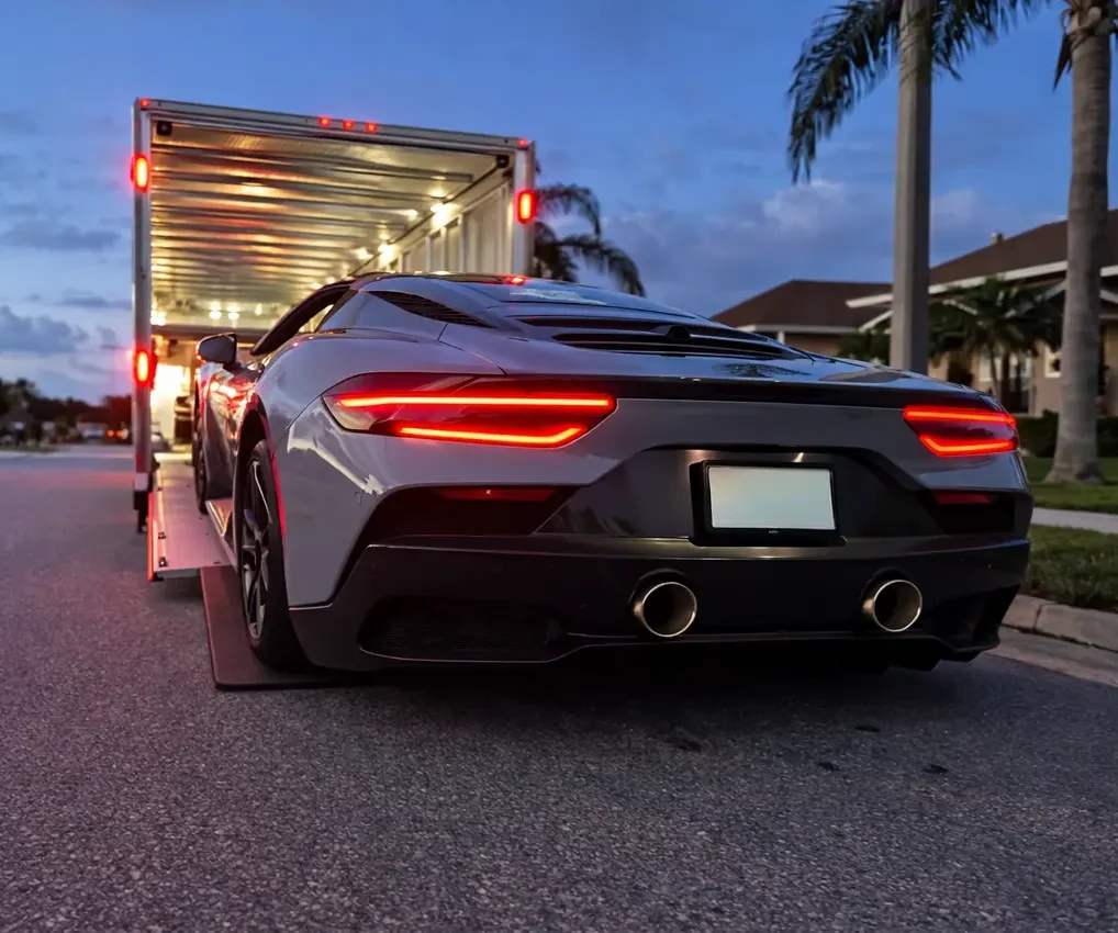 Luxury car being loaded into an enclosed trailer for secure auto transport