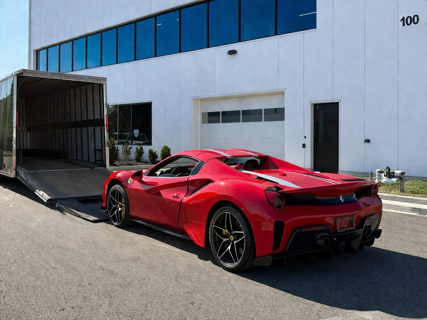 red exotic car going into enclosed trailer