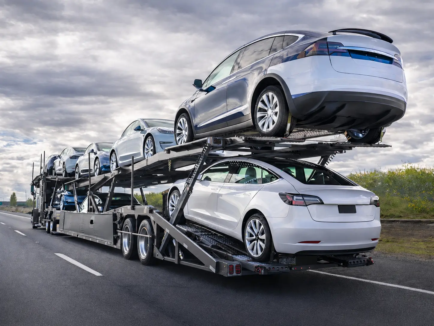 Car carrier truck transporting multiple vehicles on a highway.