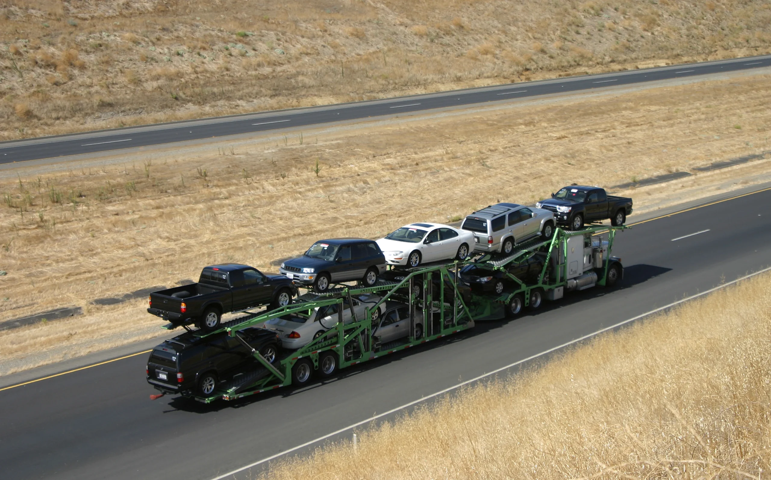Truck transporting multiple vehicles for commercial car shipping.