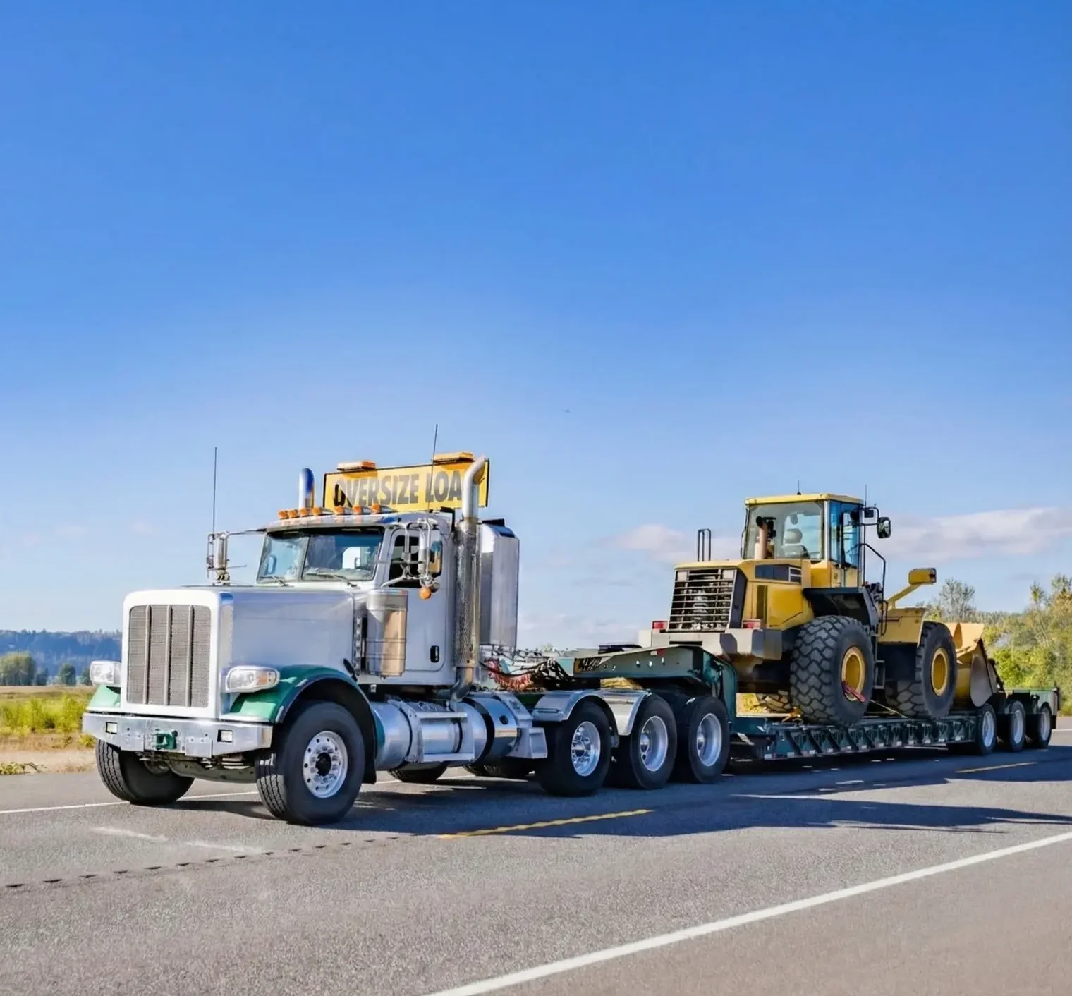 Heavy-duty truck hauling a wheel loader for oversized vehicle transport